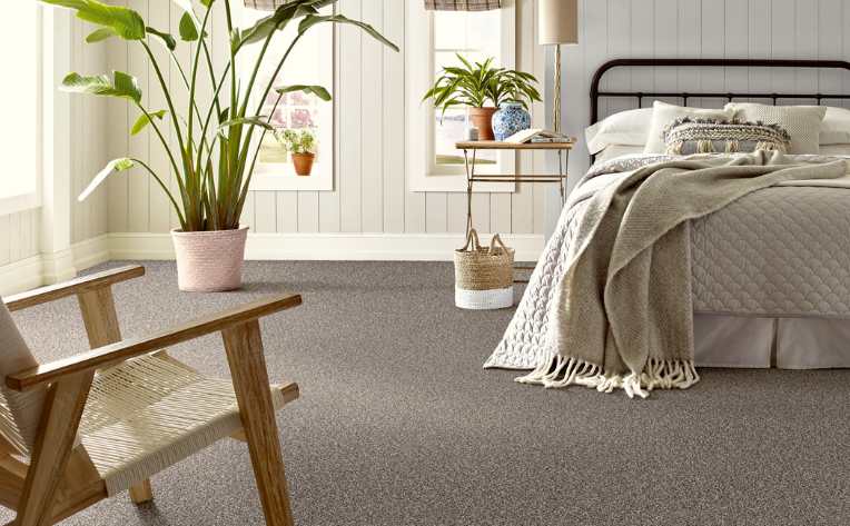 hypoallergenic carpet in bedroom with neutral colours, plants and rattan accents