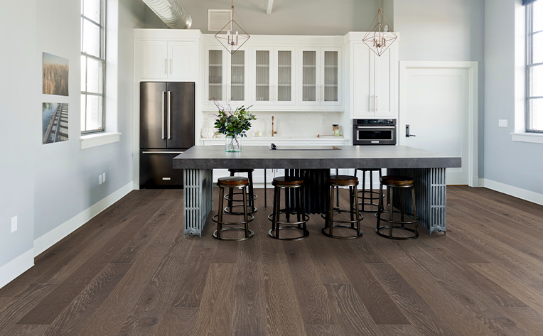 dark hardwood flooring in kitchen with stone island