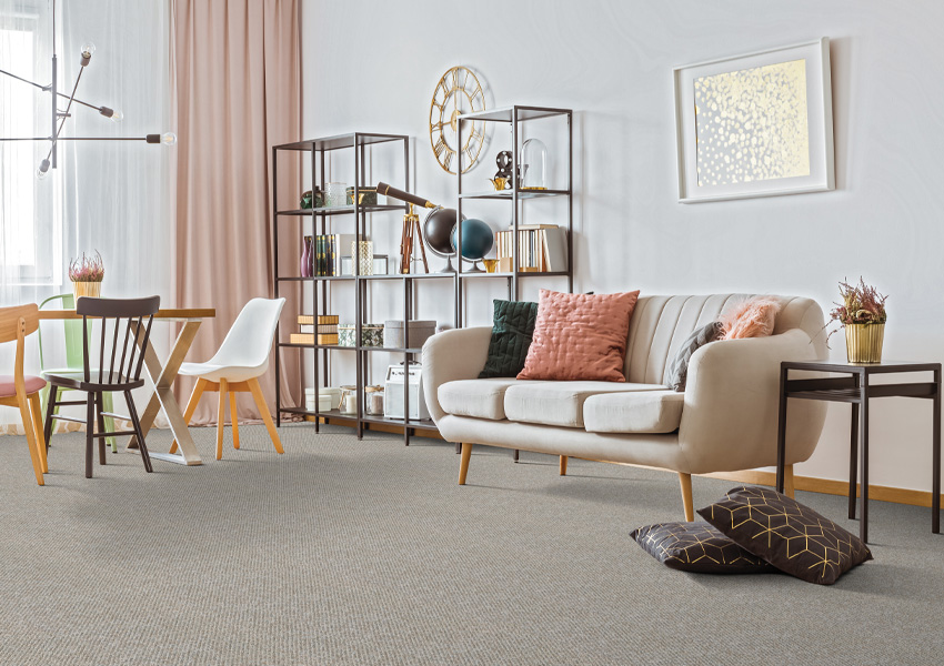 grey carpet in living room with pink and brown decor.
